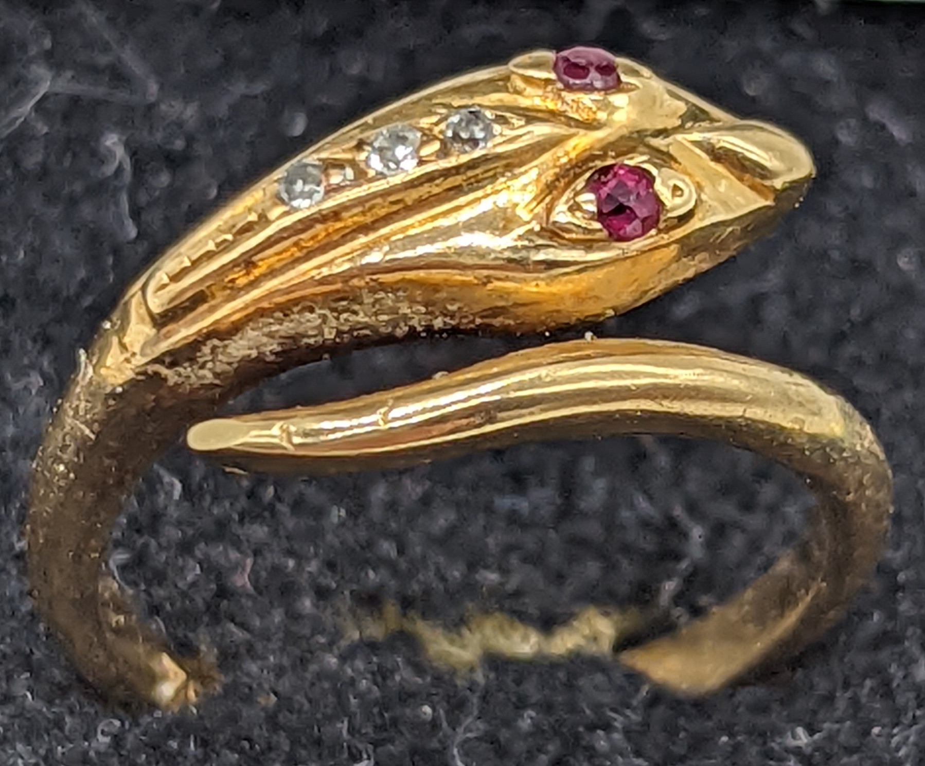 An 18ct gold snake ring, ruby eyes and 3 mounted diamonds, 3.3g