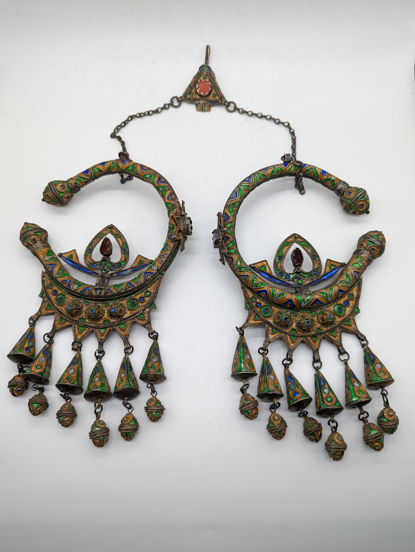 A pair of Moroccan Berber silver headdresses, enamelled with ornaments and chains