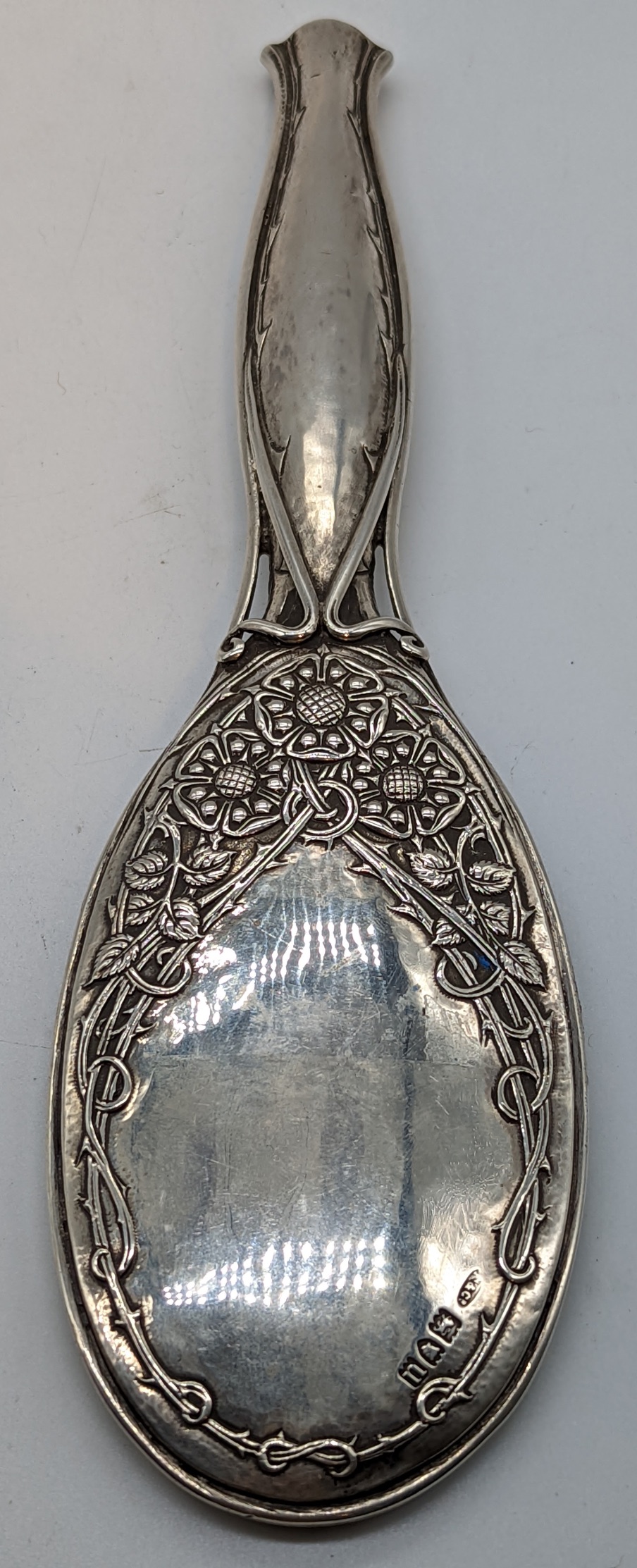 An Arts and Crafts Omar Ramsden & Alwyn Carr silver hand mirror, decorated with roses and thorns,