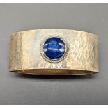 A Liberty & Co. silver napkin ring, mounted with Lapis Lazuli stone, planished finish, hallmarked
