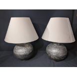 A pair of Eastern spherical silver colour table lamps, cream coloured shades