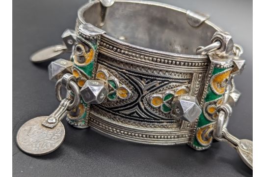 A North African Berber silver tribal bangle with yellow, green and black enameling, mounted with - Image 4 of 4