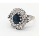 A Sapphire and Diamond cluster ring, 18ct white gold mount, oval cut Sapphire 1.01cts, surrounded by