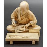 A Japanese Meiji period study of a man preparing fish, signed to base, H.6.5cm