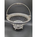 A George III silver round basket, swing handle, raised on four pad feet, hallmarked Sheffield, 1812,