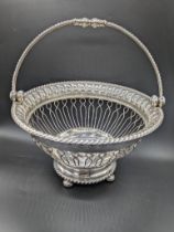 A George III silver round basket, swing handle, raised on four pad feet, hallmarked Sheffield, 1812,
