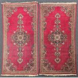 A pair of Persian Kashan red ground rugs, circa 1900, 140cm x 40cm