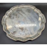An early 20th century silver salver, raised on 3 scrolling feet, hallmarked Sheffield 1960, maker