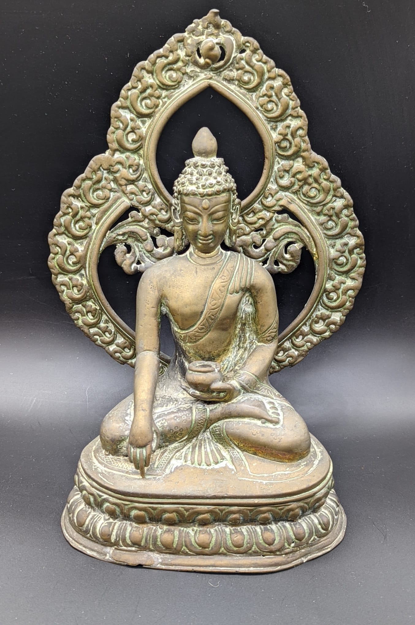 An 18th or 19th century Tibetan or Nepalese brass Buddha, traces of gilding to the rear, H.23cm