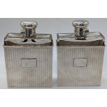 A pair of silver cased glass flasks, silver lids, the silver cases with striped decor and vacant