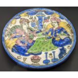 A 19th century Persian Qajar glazed pottery dish depicting a figural scene, D.24cm