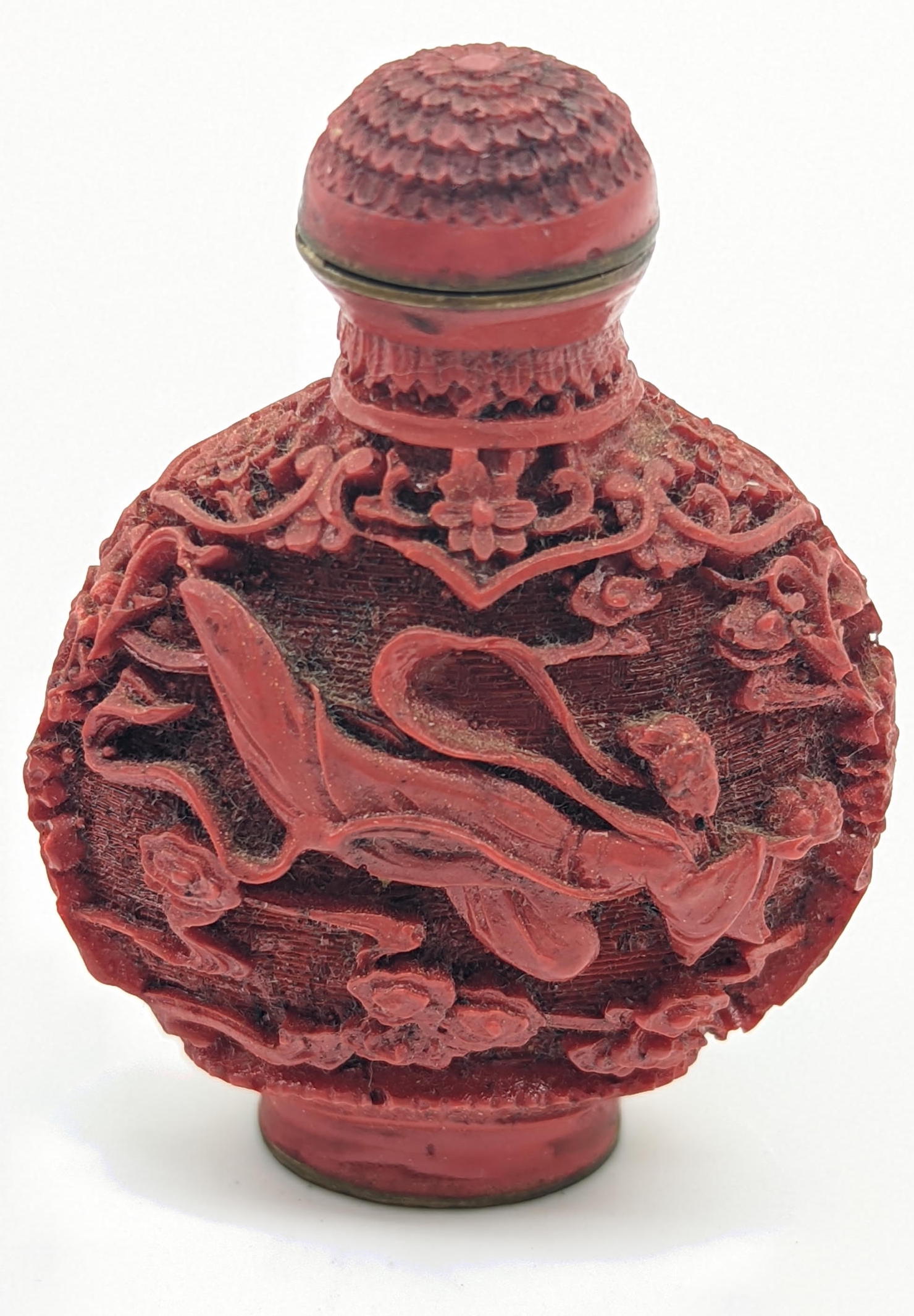 A Chinese red lacquered snuff bottle, carved designs depicting a flying maiden, signed to base,