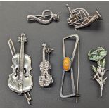 A collection of brooches, mostly musical instruments, violins, some silver