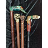 Four walking sticks with tops depicting dogs and a duck