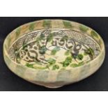 A rare 13th century Garrus ware glazed pottery bowl depicting a ram amongst foliage, H.10.5cm W.