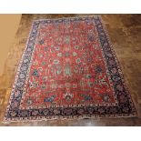 A very large Persian Heriz carpet, central motif on a red ground, surrounded by navy and cream