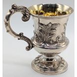 A Victorian silver christening mug, scrolling decor to the body and base, gilt interior,