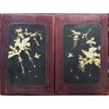 A pair of Japanese Meiji period wooden panel mounted with mother of pearl and bone depictions of