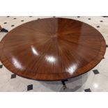 A flame mahogany and rosewood dining table, four splayed legs with brass paw casters, top diameter
