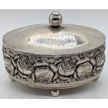 An early 20th century Continental silver caddy, planished lid, the body with chased roses, raised on