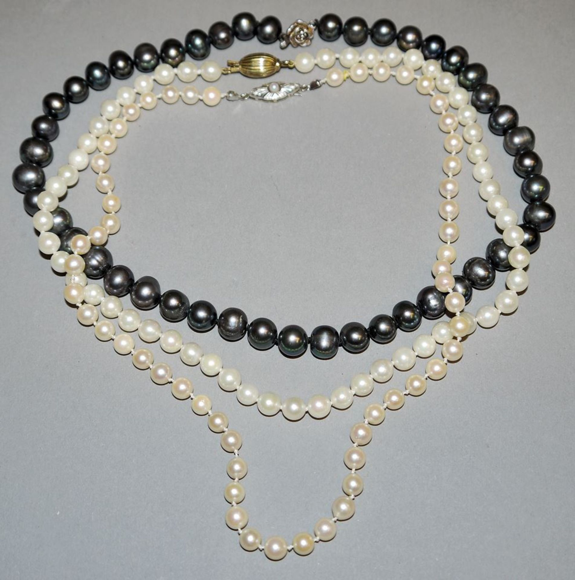 Drei Perlenketten, Zucht- und Süßwasserperlen, einmal grau, Silber/ Gold