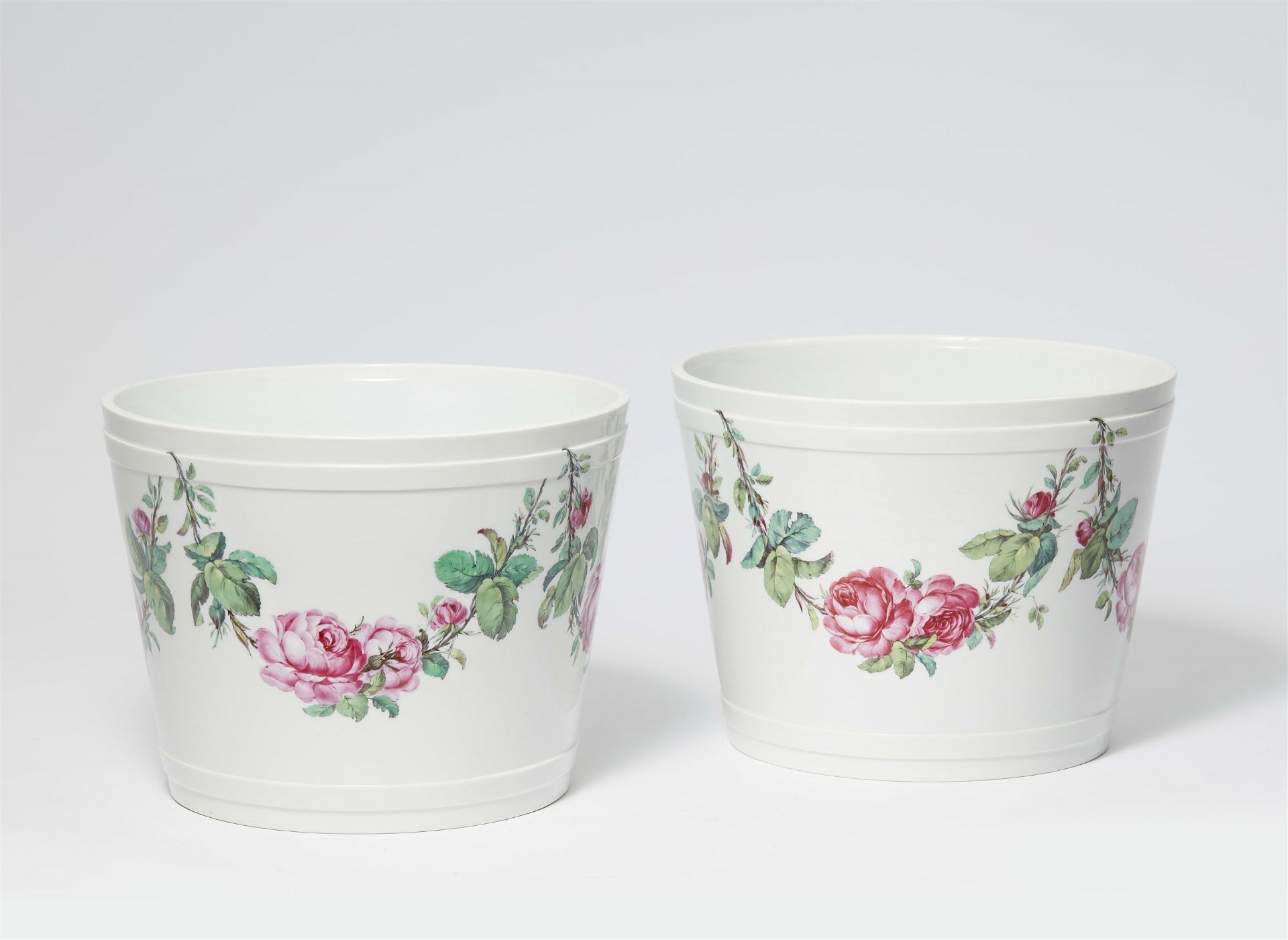A pair of Berlin KPM porcelain cachepots with rose garlands