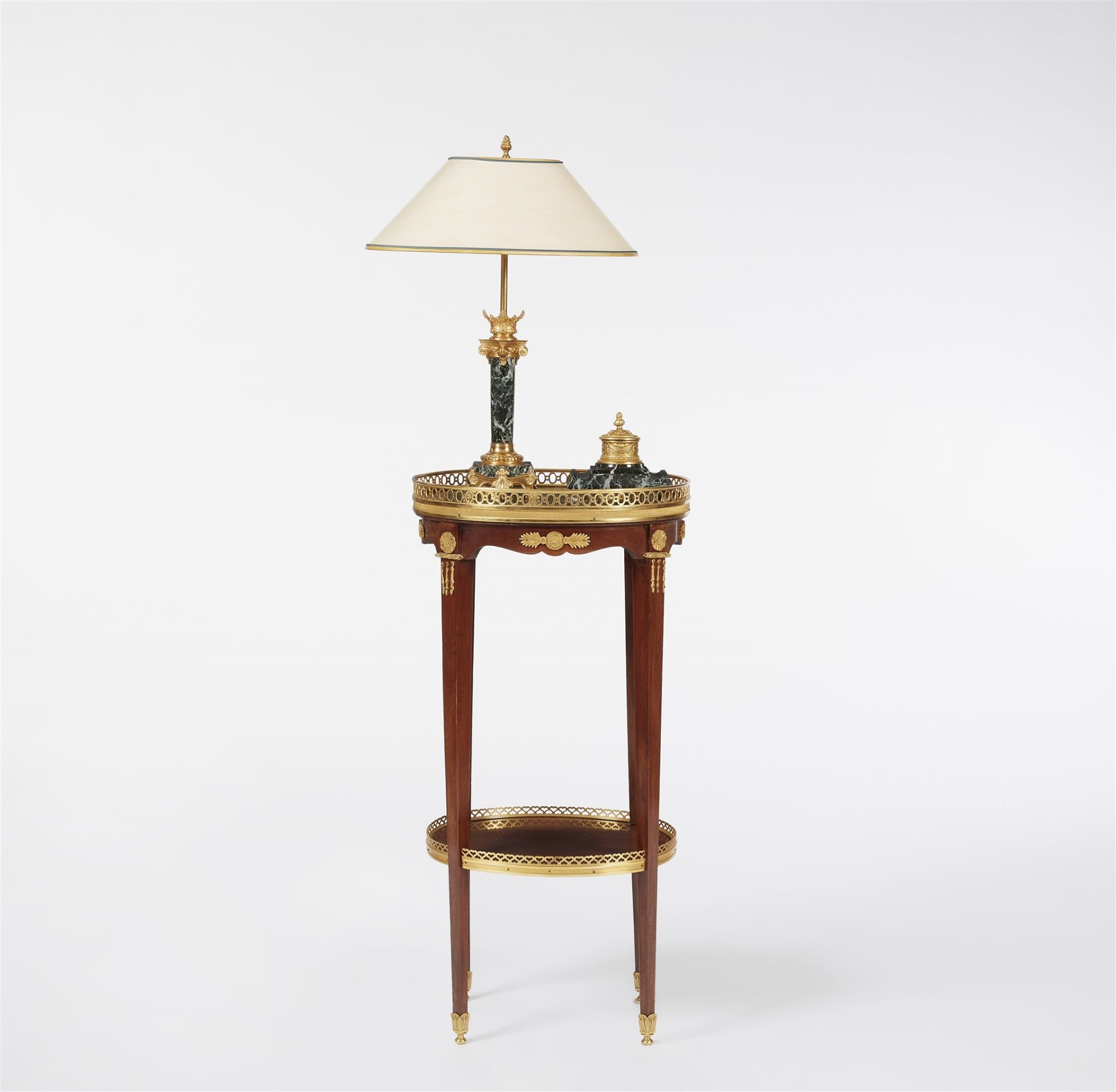 A mahogany gueridon with a table lamp and ink well