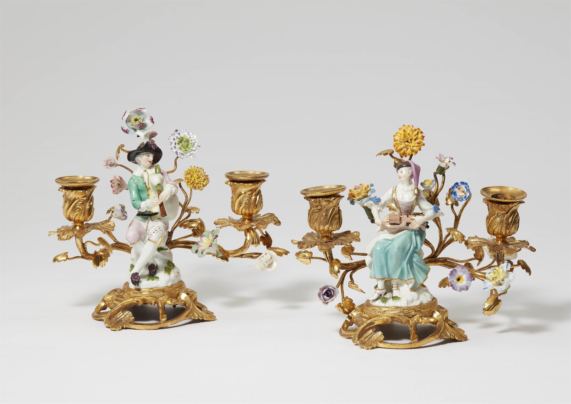 A pair of candlesticks with Meissen porcelain figures