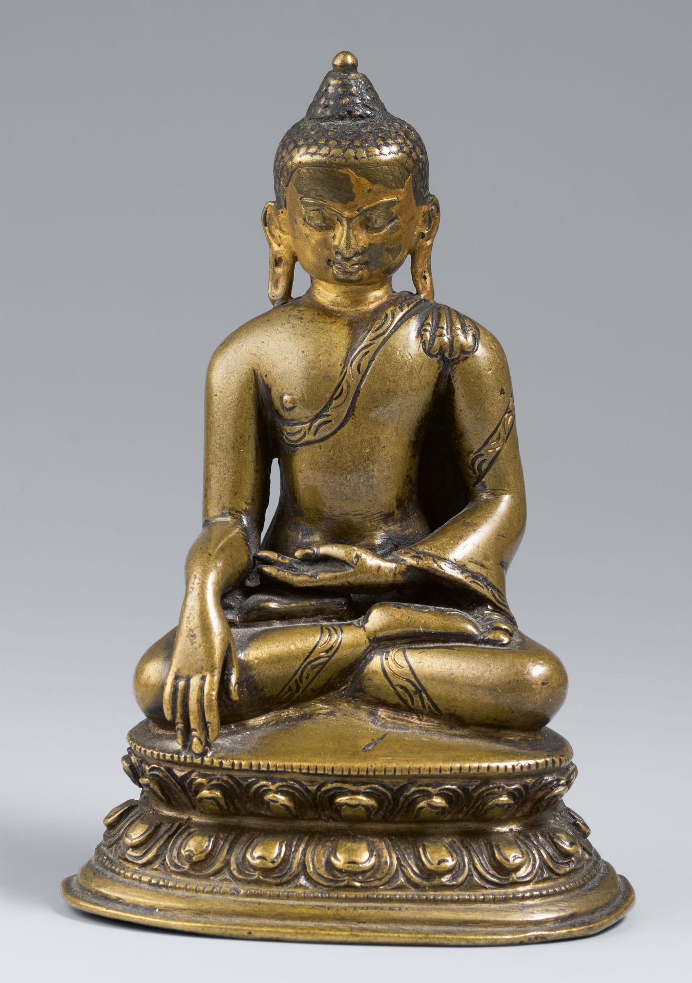 A Tibetan copper alloy figure of Buddha Shakyamuni with cold gold. 14th/15 century