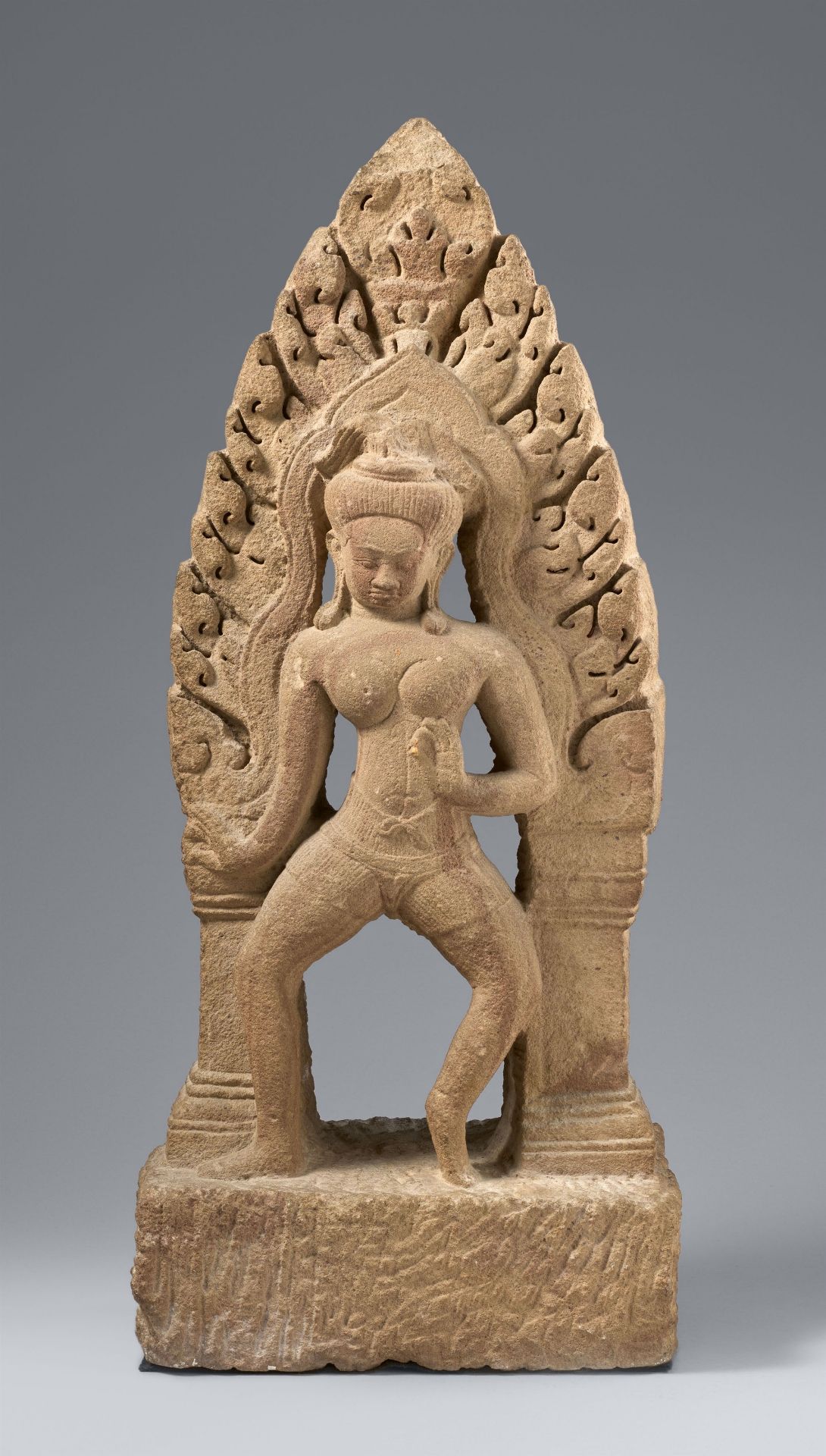 A beige sandstone antefix or pediment of a dancing figure. Cambodia.