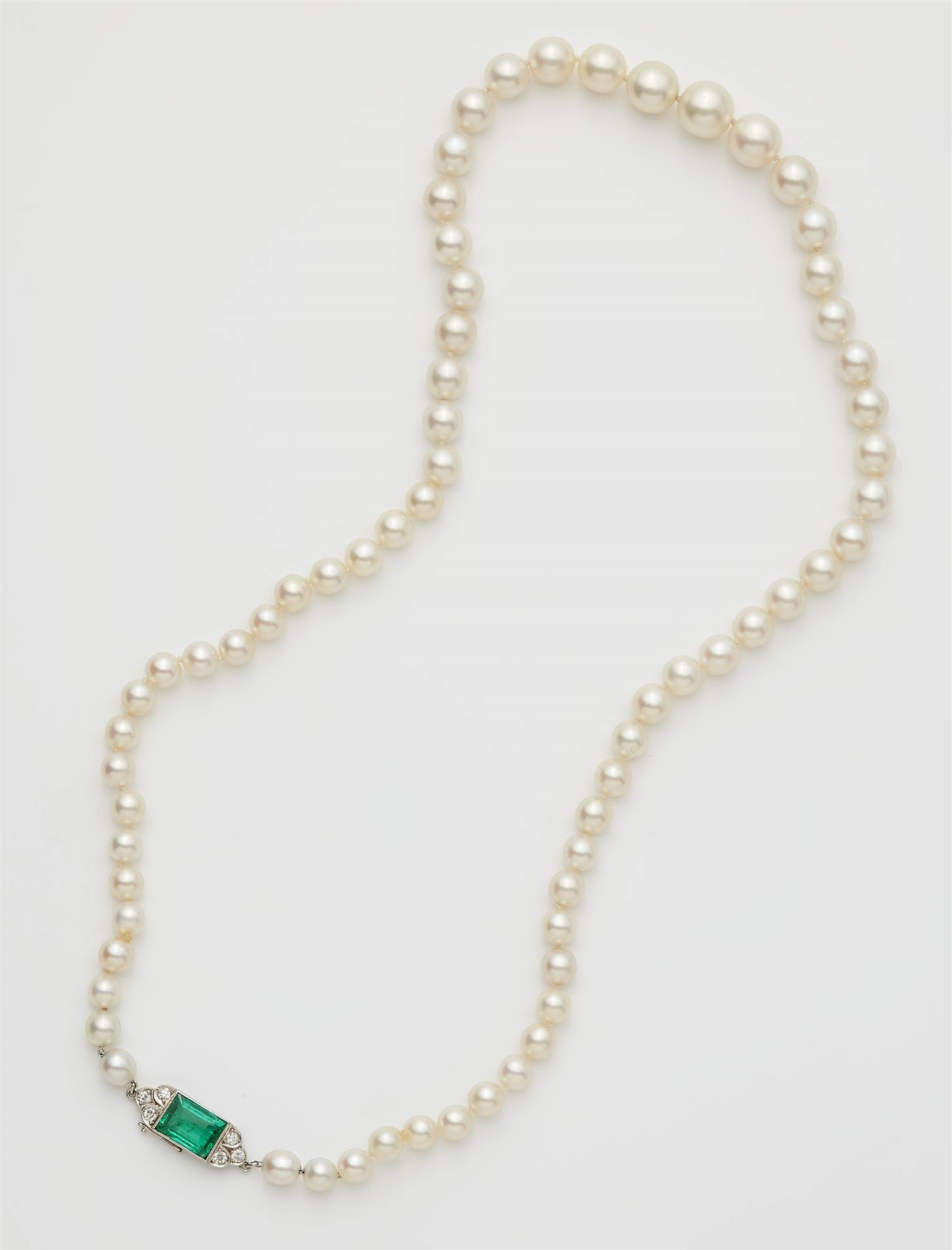 An Art Deco cultured pearl necklace with an 18k gold emerald and diamond clasp.