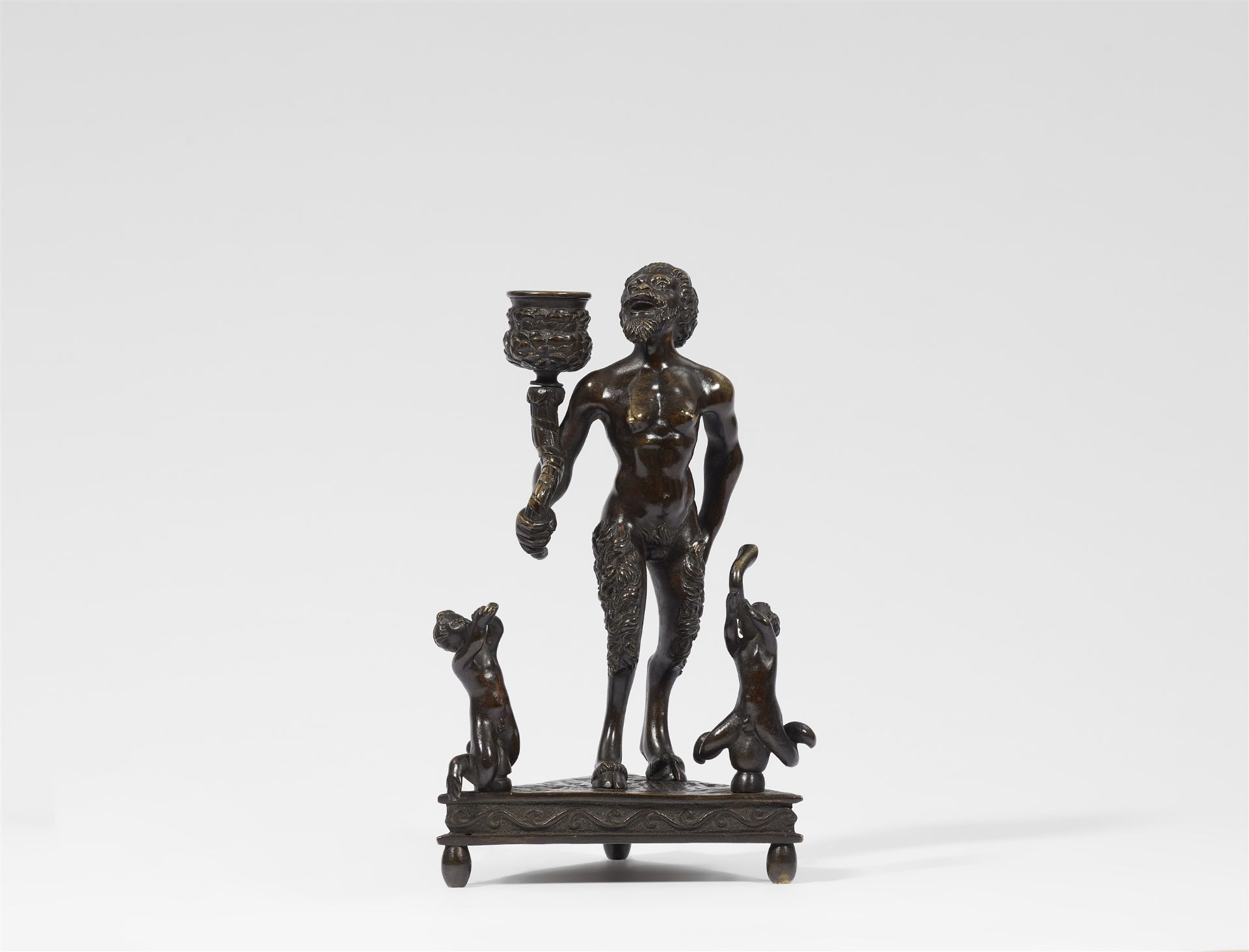A bronze satyr candlestick