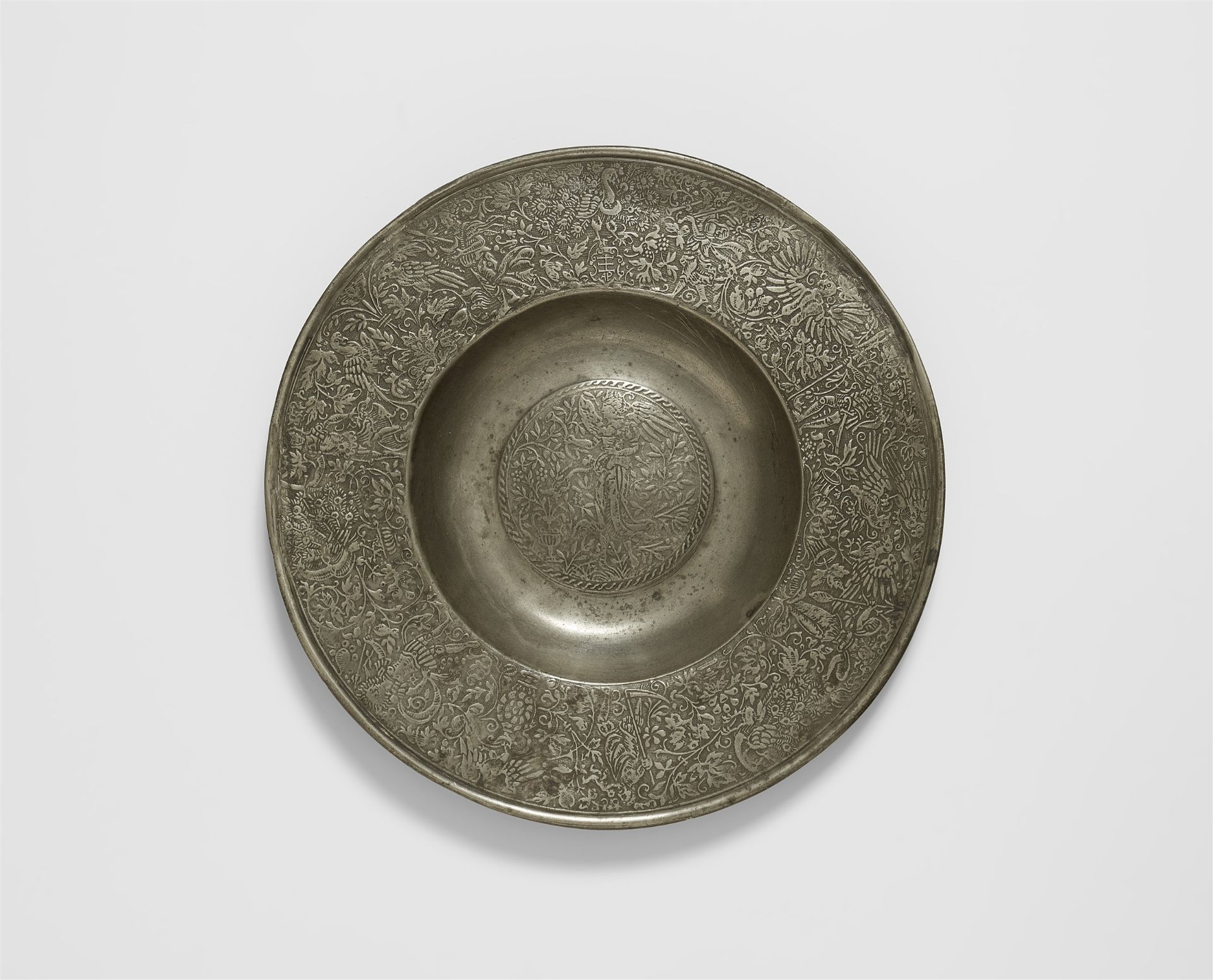 A broad rimmed pewter plate with a figure of Fama