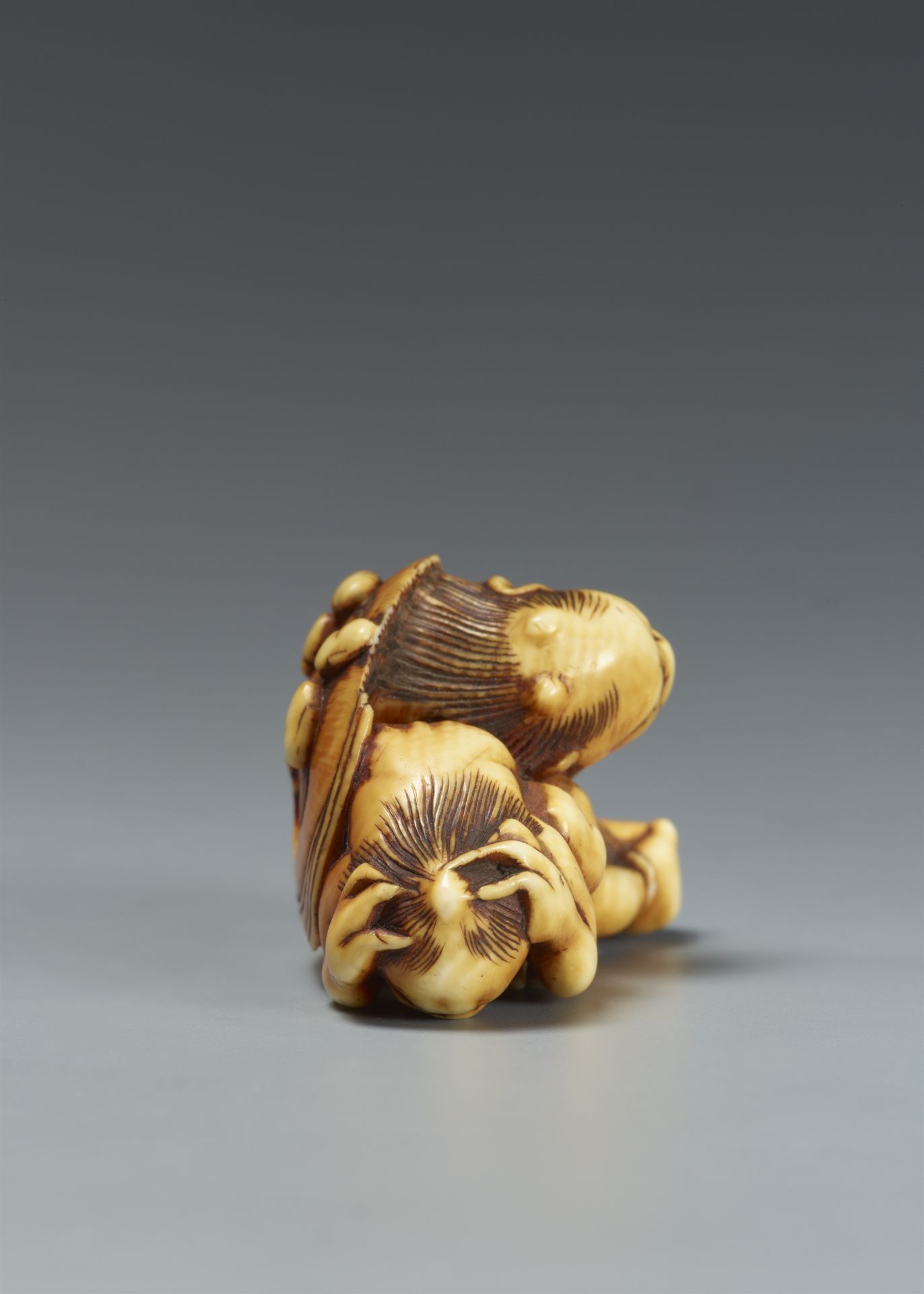 A partly stained ivory netsuke of two oni at setsubun. Hakata, attributed to Otoman. Ca. 1830 - Image 3 of 5