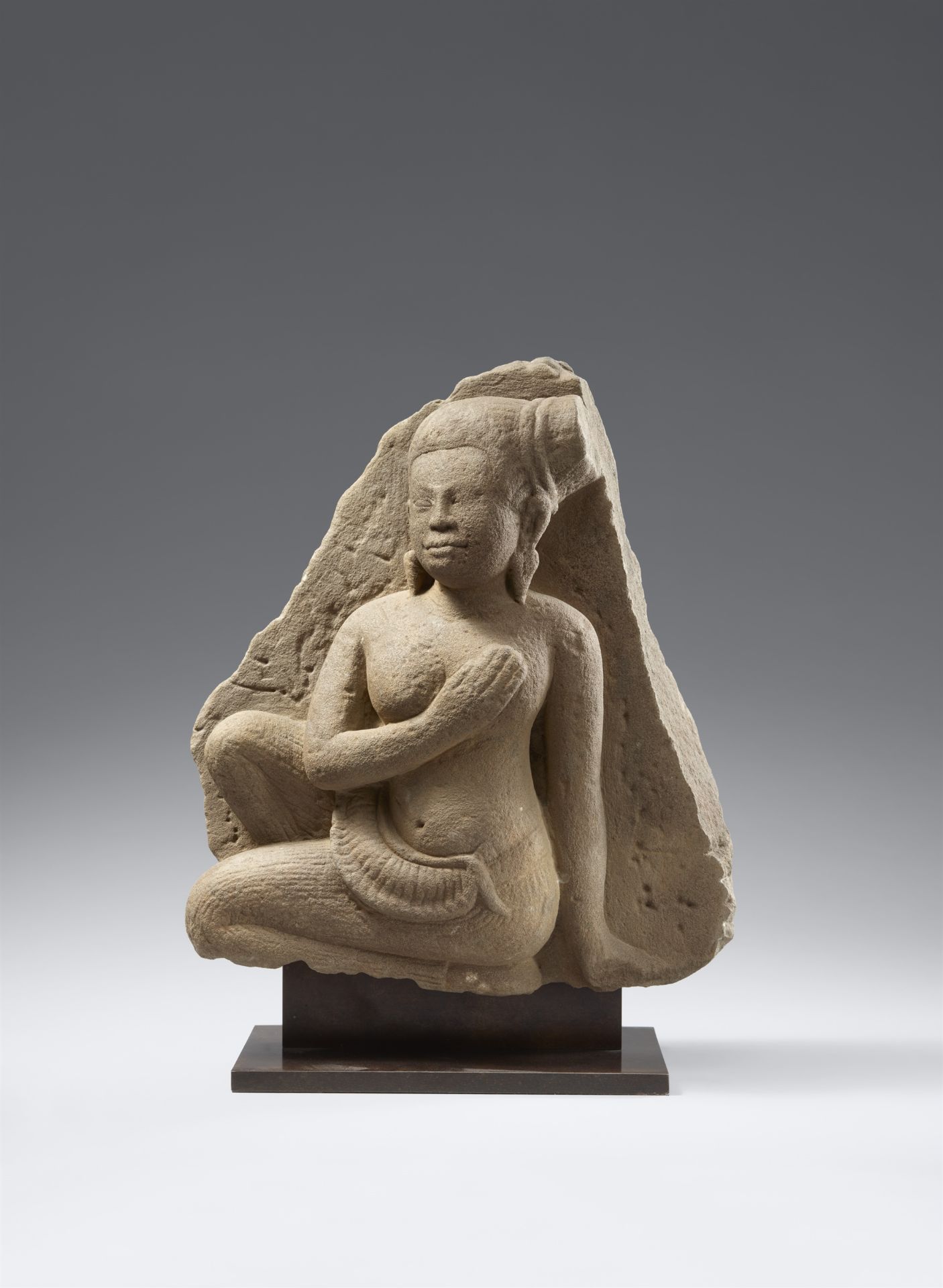 An Angkor Wat-style sandstone figure of a female attendant. Cambodia. 12th century