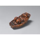 A boxwood netsuke of Hotei resting in a boat. Late 19th century