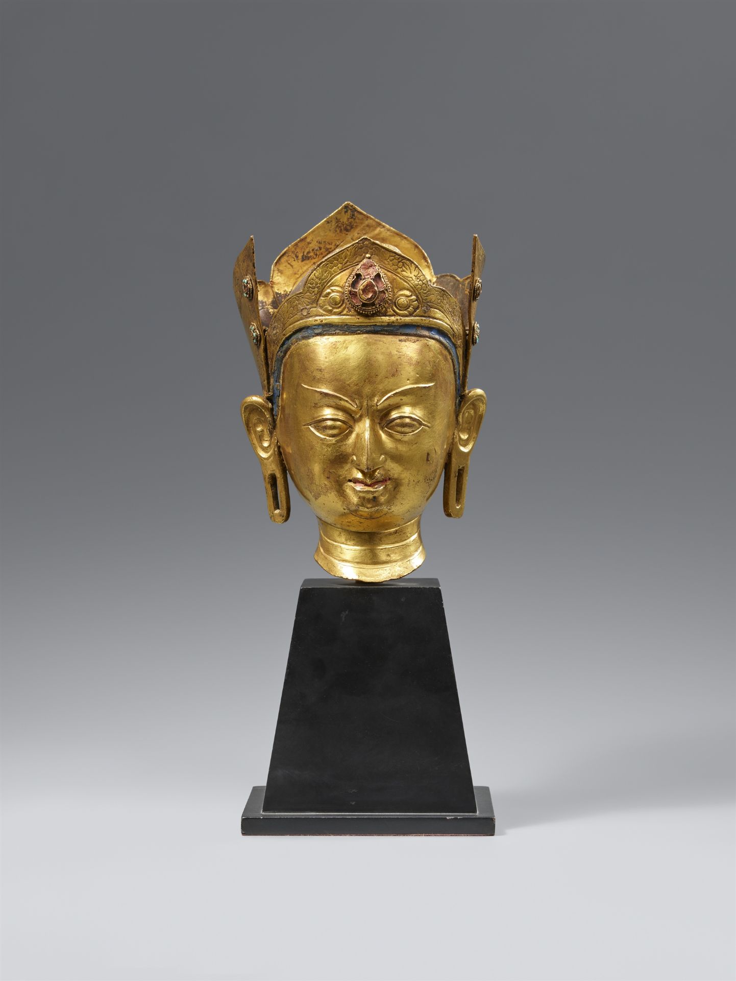 A fire-gilt bronze head of Padmasambhava. Tibet. 18th century.