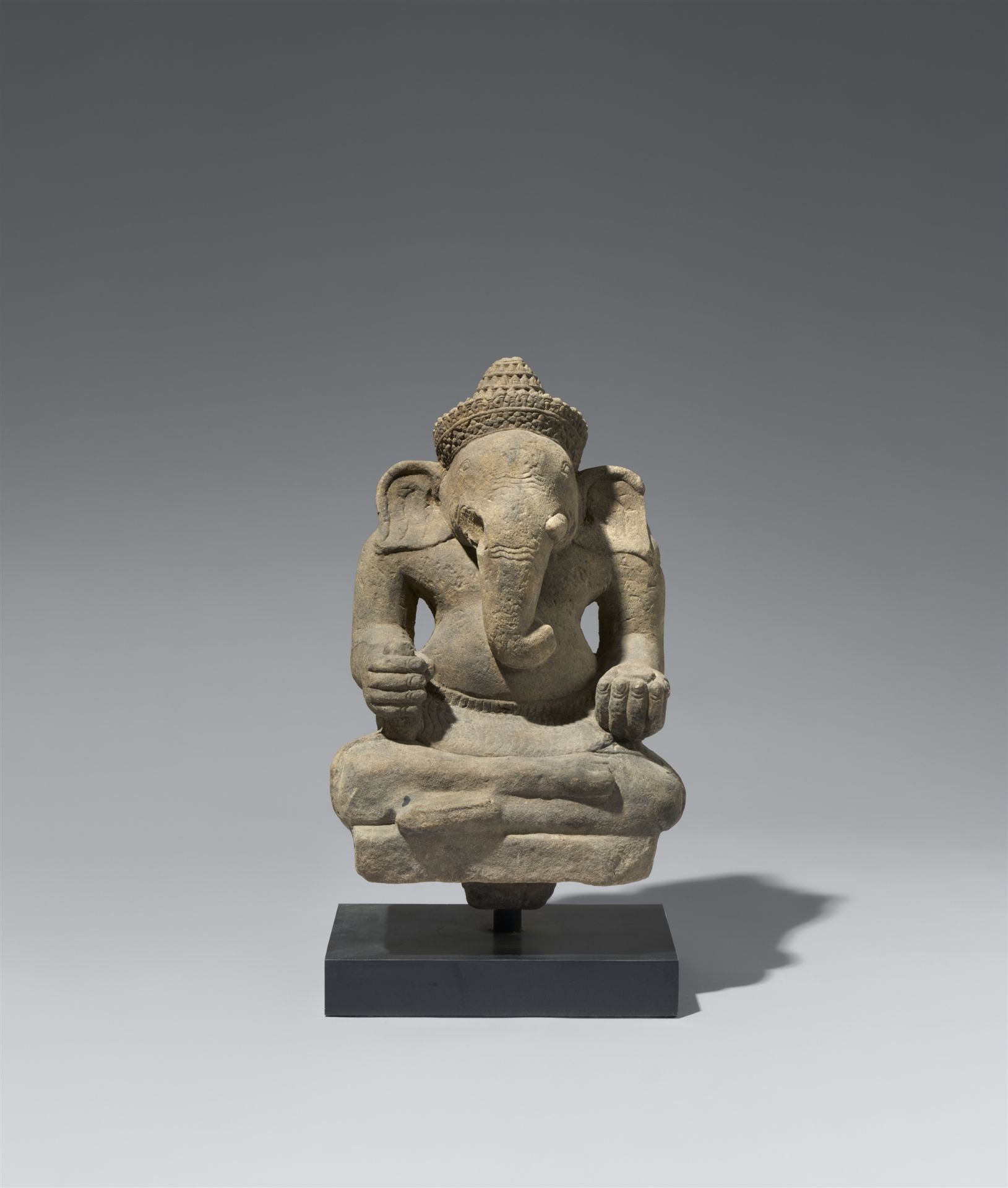 An Angkor Wat-style sandstone figure of a seated Ganesha. Cambodia. 12th century