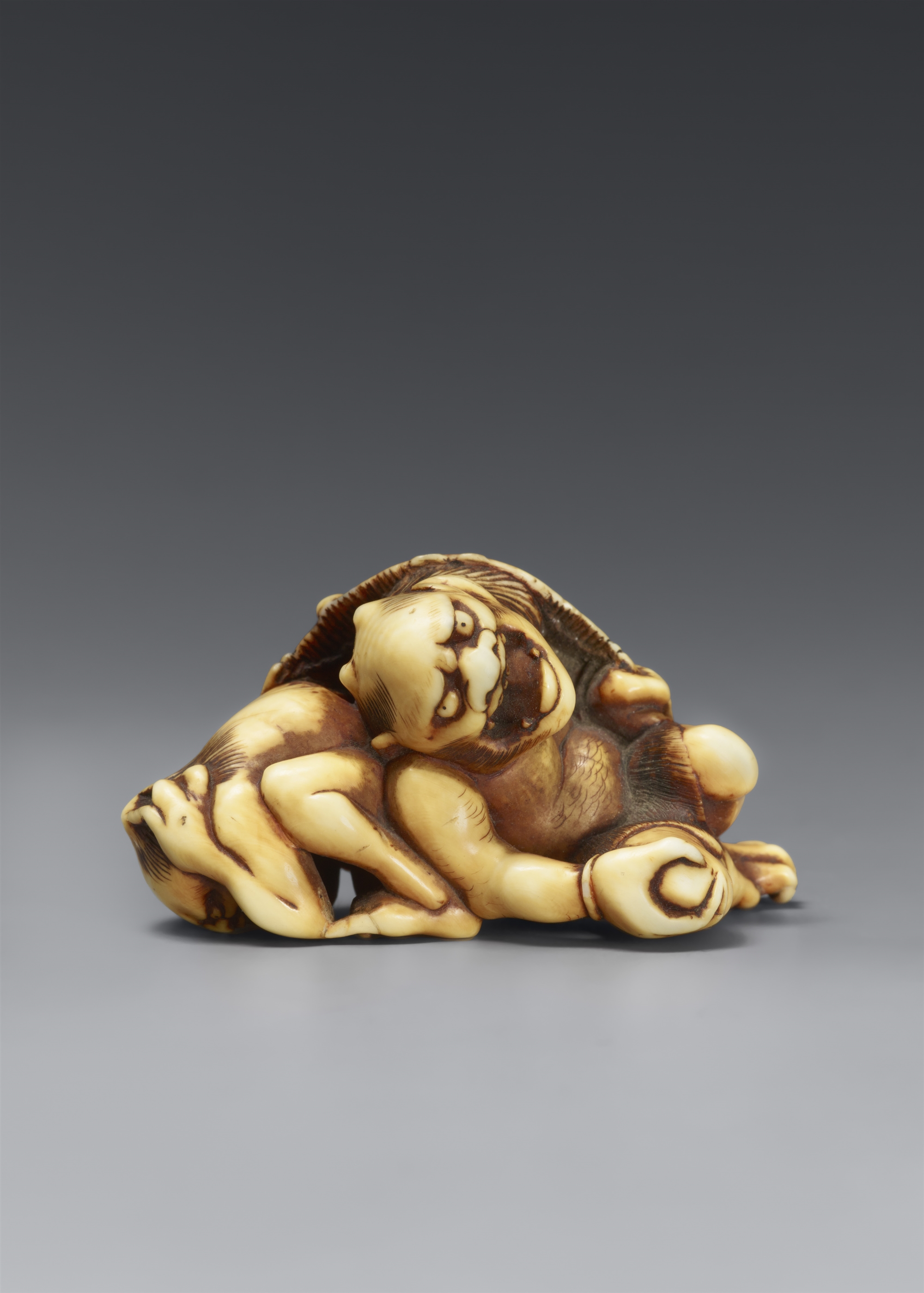 A partly stained ivory netsuke of two oni at setsubun. Hakata, attributed to Otoman. Ca. 1830
