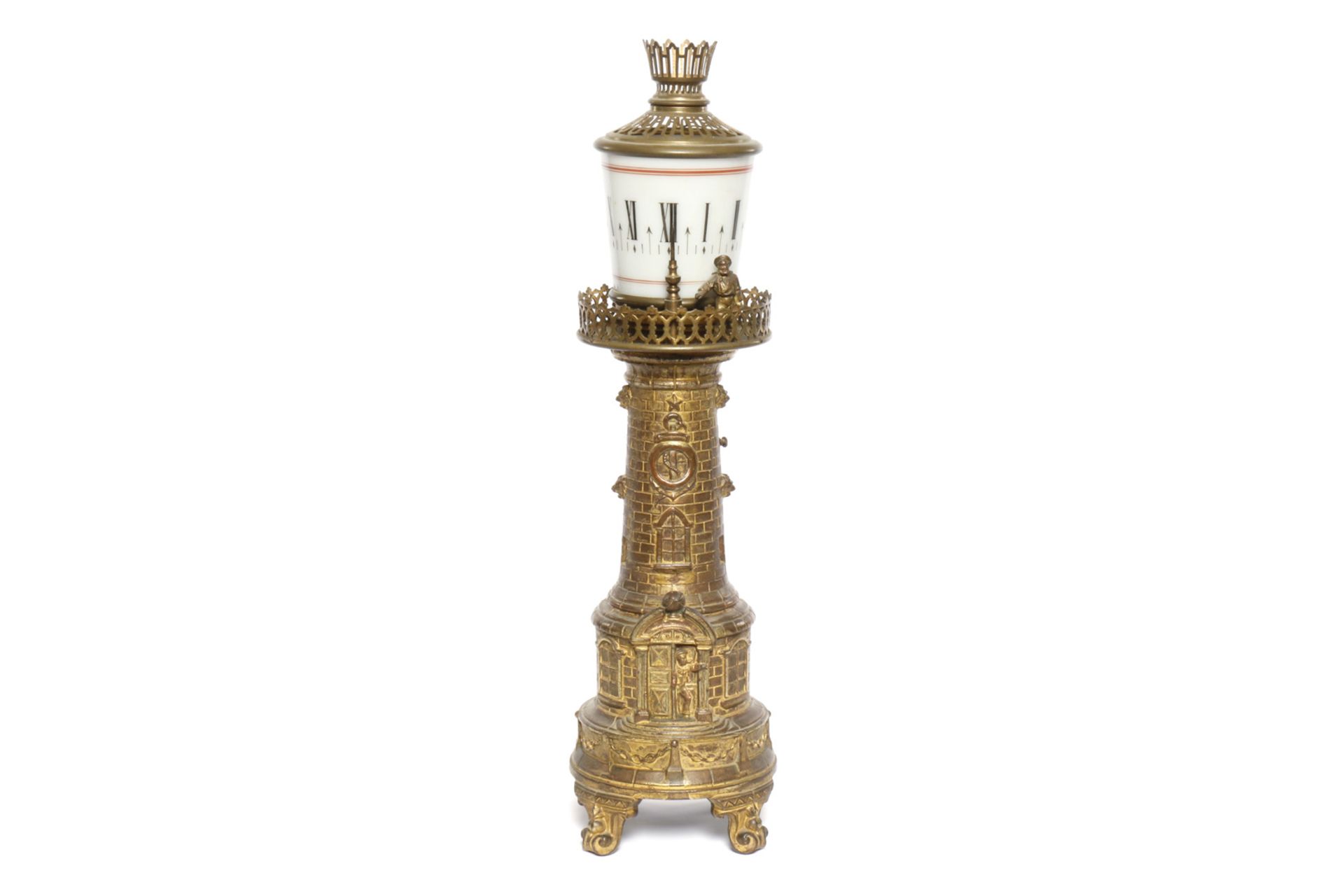 Leuchtturmuhr, Guss, vergoldet, um 1900, mit dreh- und beleuchtbarem Glasaufsatz mit römischen