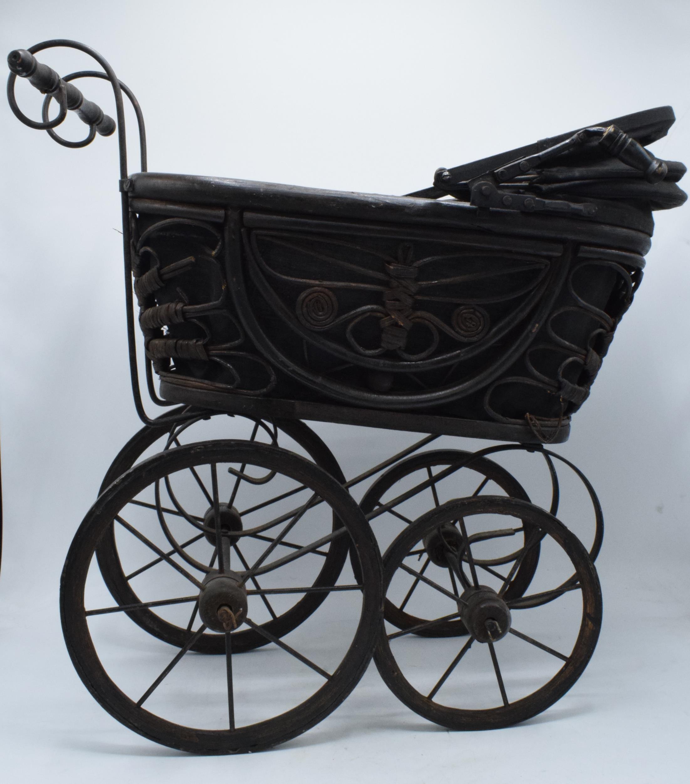 Am early to mid 20th century ornate dolls pram on wooden and metal wheels. 58cm tall. - Image 2 of 8