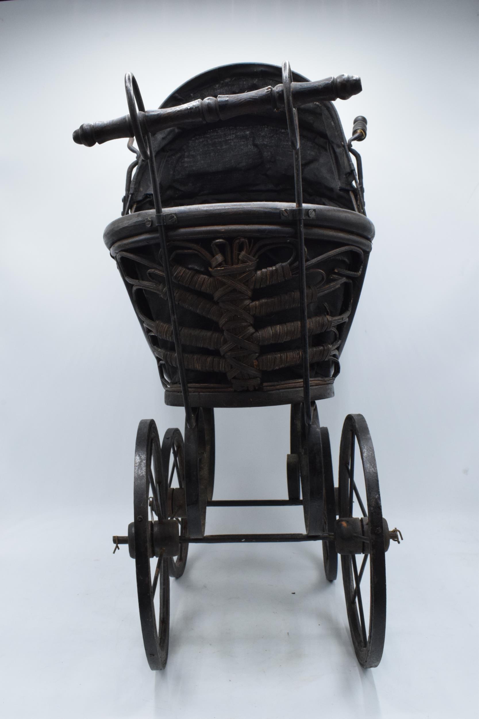 Am early to mid 20th century ornate dolls pram on wooden and metal wheels. 58cm tall. - Image 8 of 8