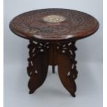 A 20th century Middle Eastern collapsible wooden table with carved and inlaid decoration. 39cm tall.