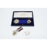 A cased silver attendance medal together with a George V commemorative coin and a Masonic type jewel
