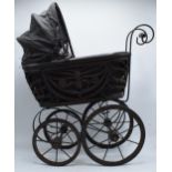 Am early to mid 20th century ornate dolls pram on wooden and metal wheels. 58cm tall.