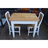 A 20th century pine-topped kitchen table with a single draw and 2 dining chairs decorated with a
