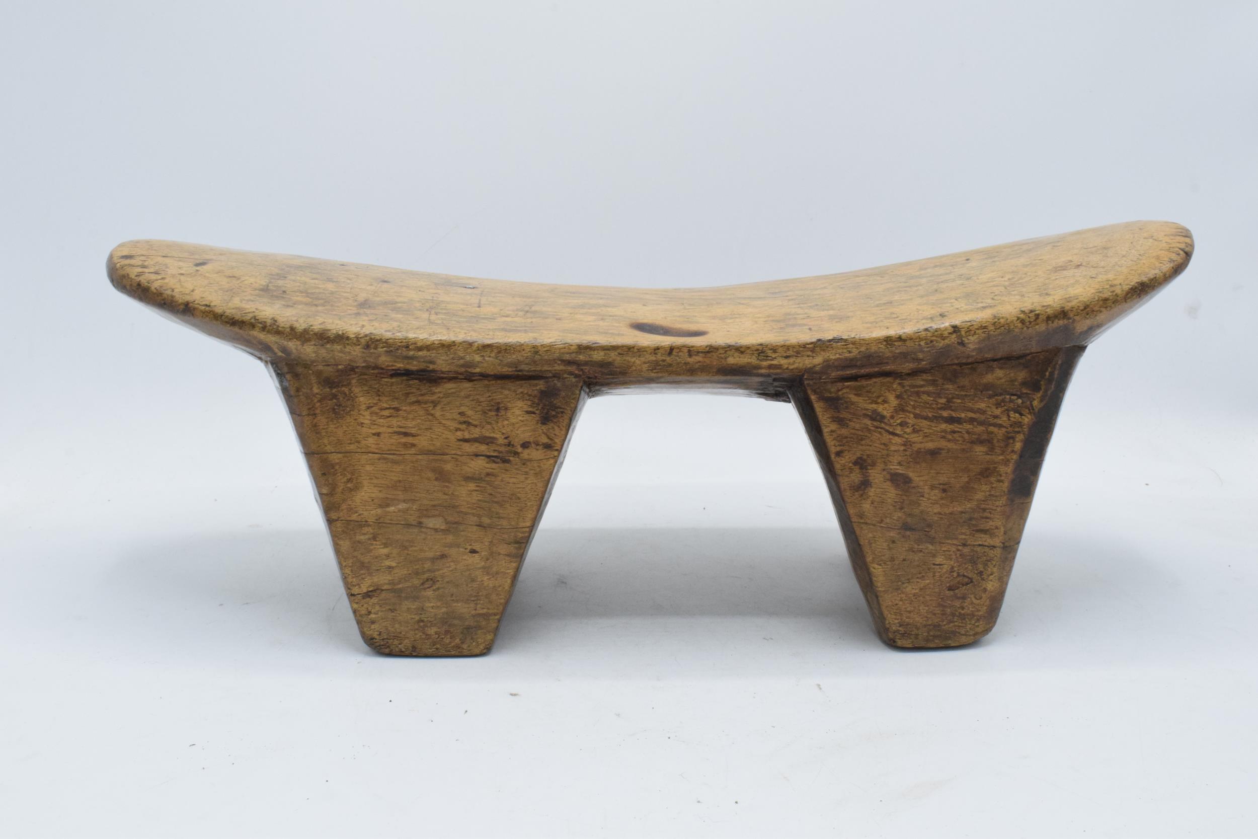 An early to mid 20th carved wooden headrest, believed to be of African origin. 43cm long.