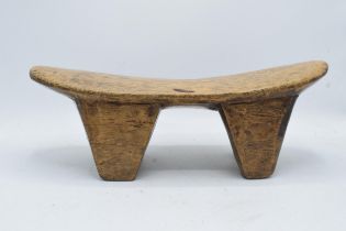 An early to mid 20th carved wooden headrest, believed to be of African origin. 43cm long.