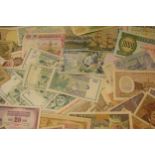 A mixed collection of bank notes from across the world to include examples from Singapore, Ghana,