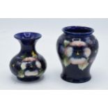 A pair of Moorcroft vases in the pansy design, both a/f. Tallest 11cm tall.